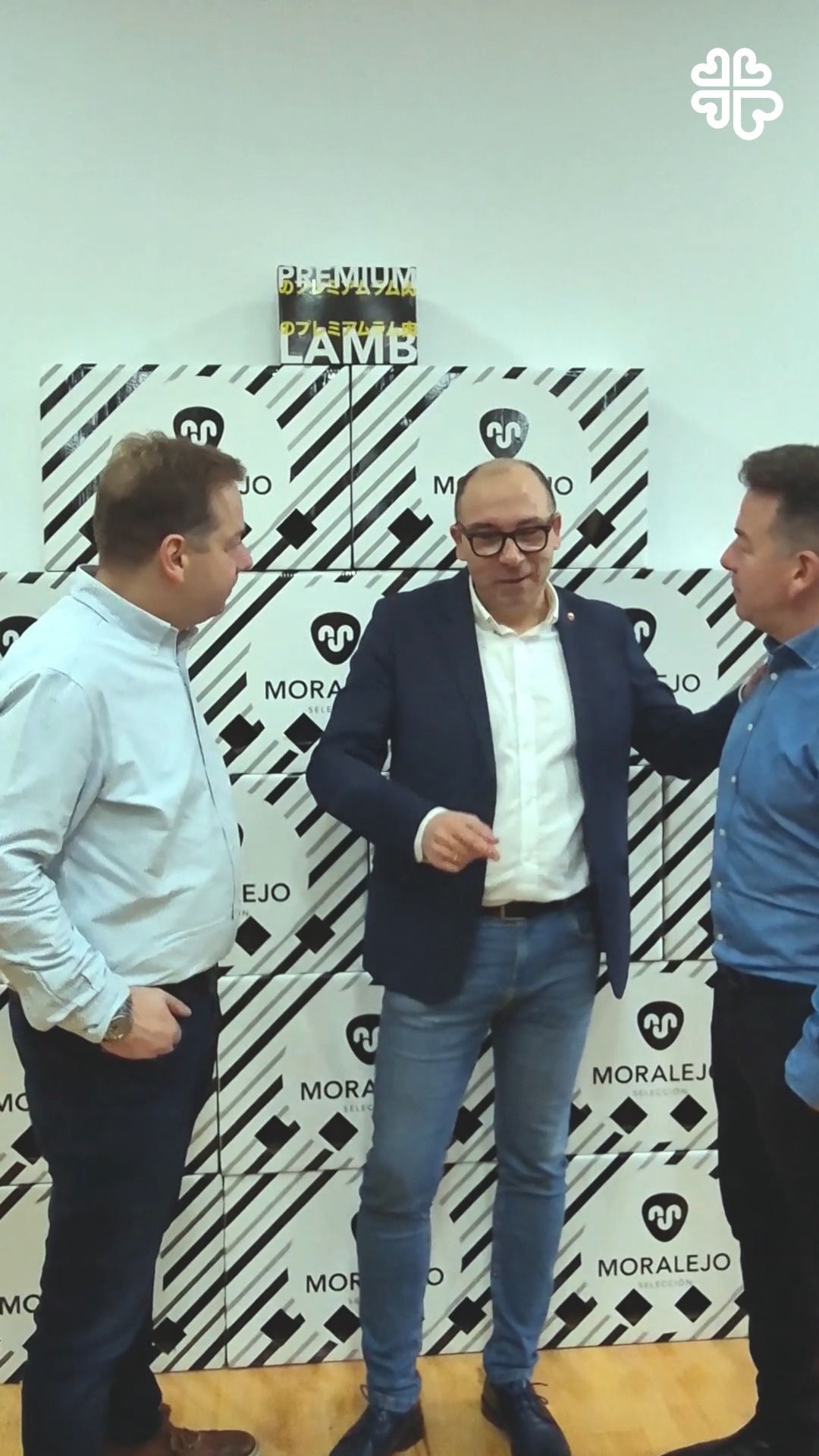 Tres hombres conversando en un evento de Nochebuena con cordero de Moralejo Selección.