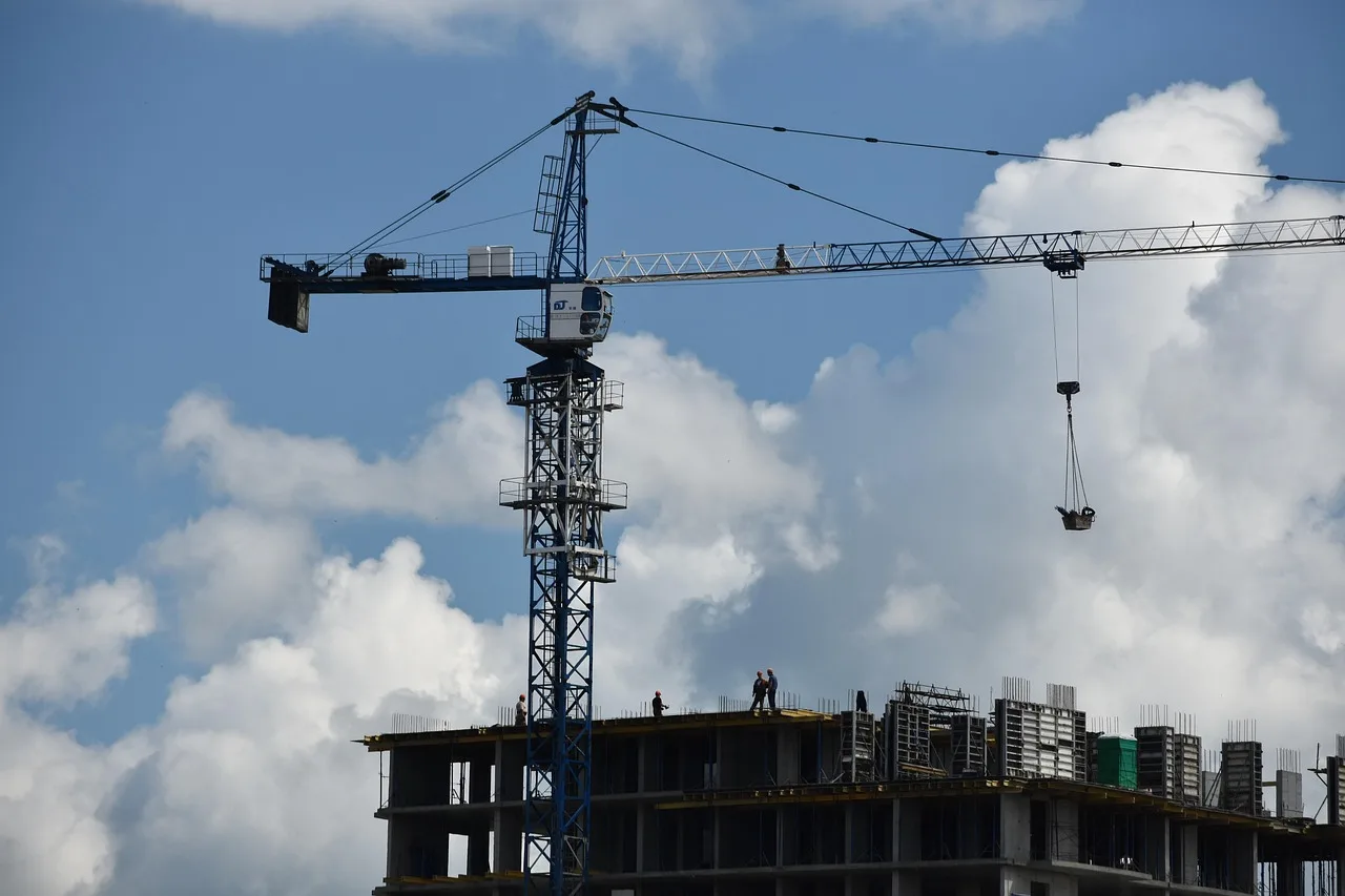 Construcción de un edificio con grúa y trabajadores en el sitio