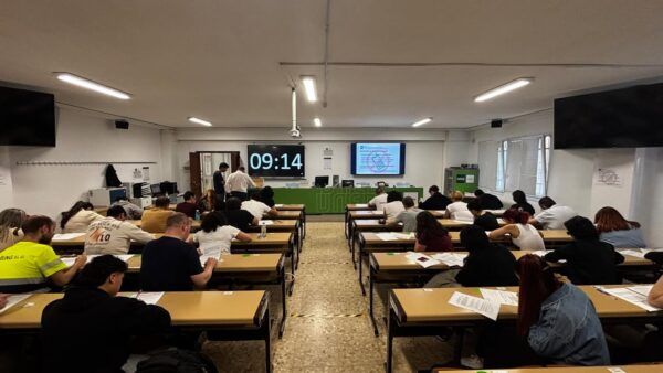 Estudiantes realizando exámenes en UNED Zamora con un reloj visible