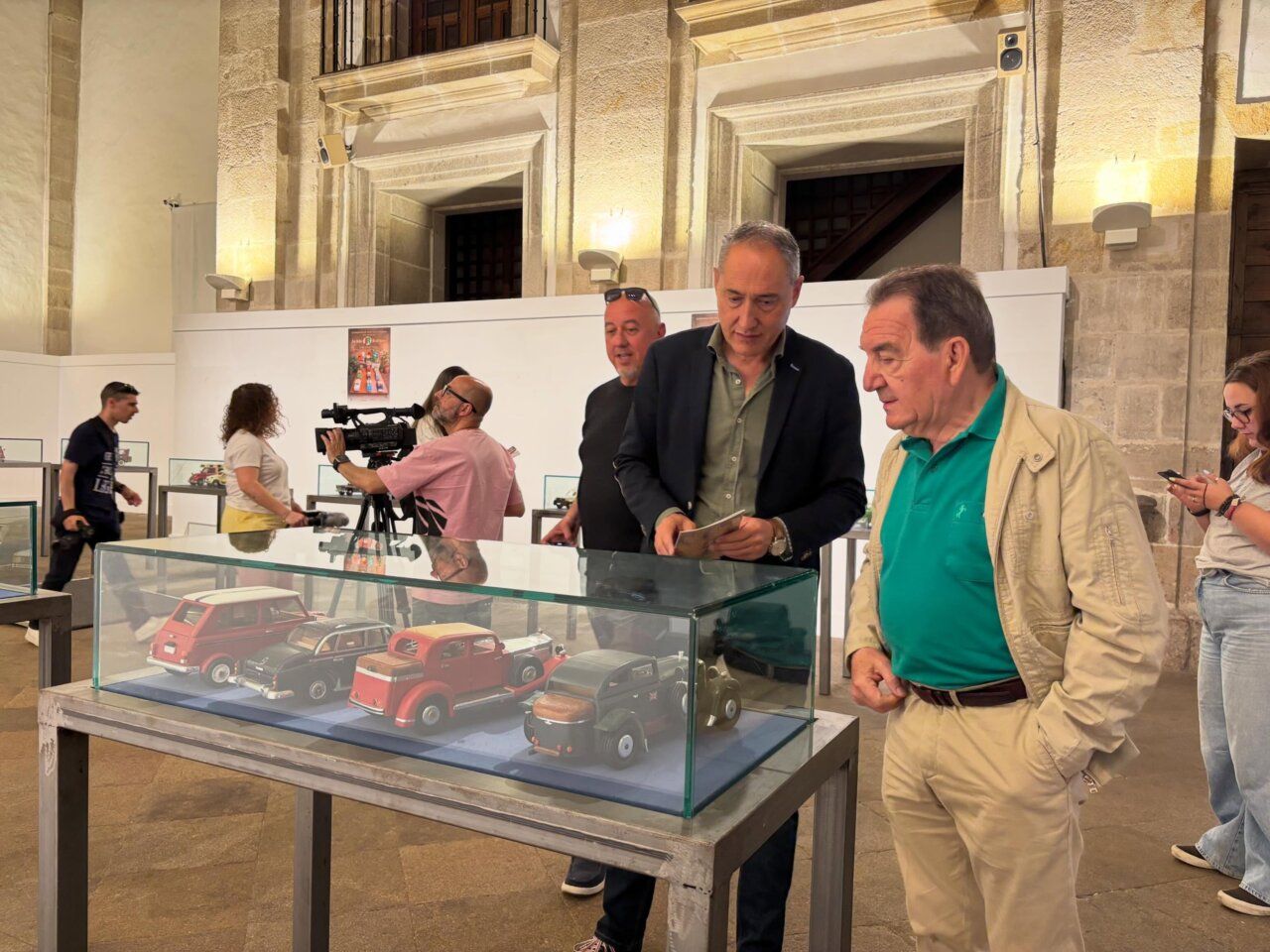 Visitantes observando vehículos de madera en exposición de artesanía