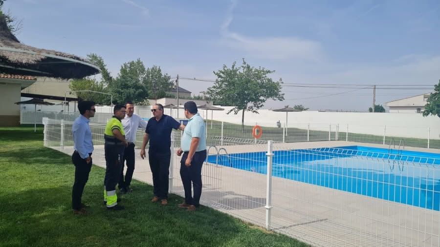Grupo de personas conversando junto a una piscina renovada en Moraleja del Vino