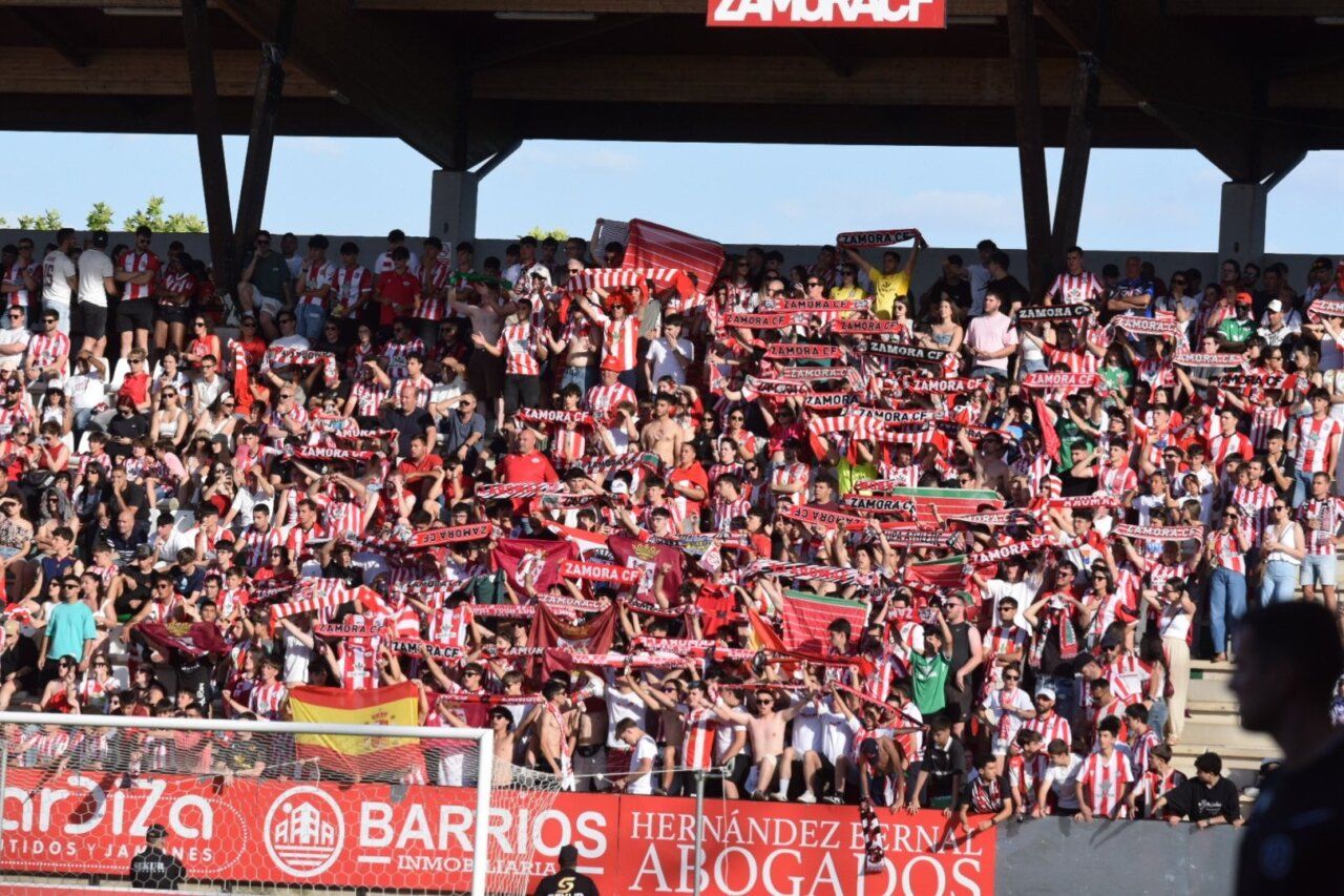 Aficionados del Zamora CF celebrando en el estadio con bufandas