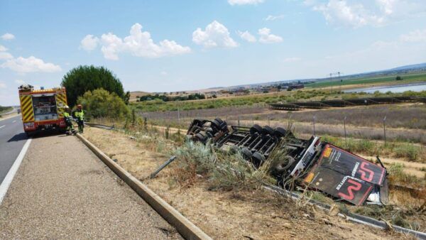 Accidente de tráfico en la A-11 con un camión volcado y bomberos trabajando