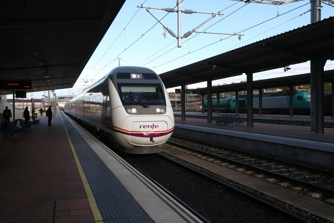 Tren de Renfe en una estación con viajeros esperando