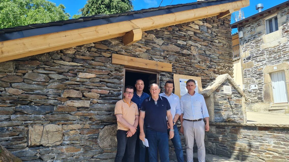 Grupo de personas frente a una construcción de piedra en Sanabria