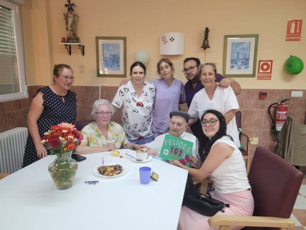 Grupo de personas celebrando el 102 cumpleaños de Antonio en una residencia