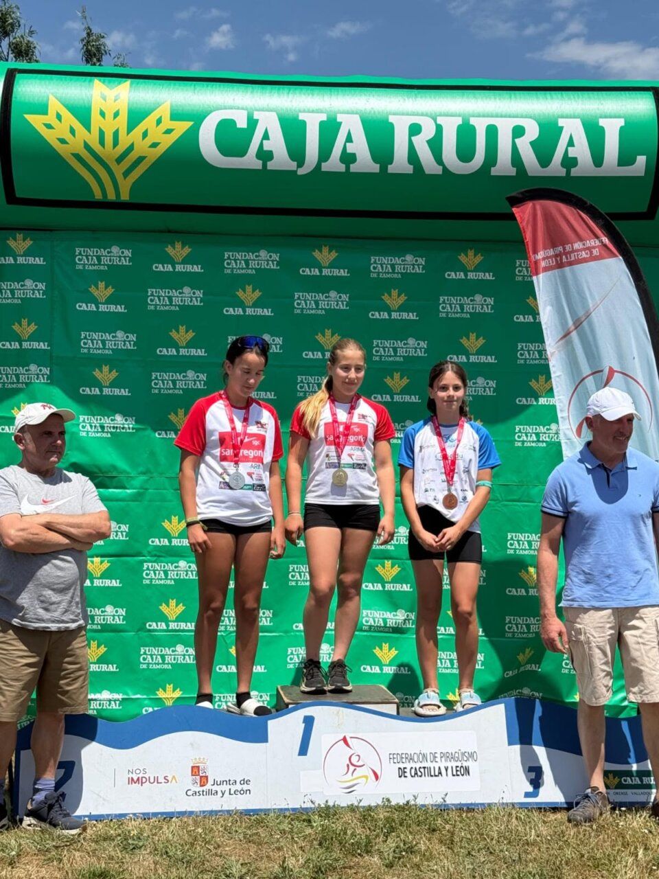Tres jóvenes atletas en el podio con medallas en Cubillas de Rueda