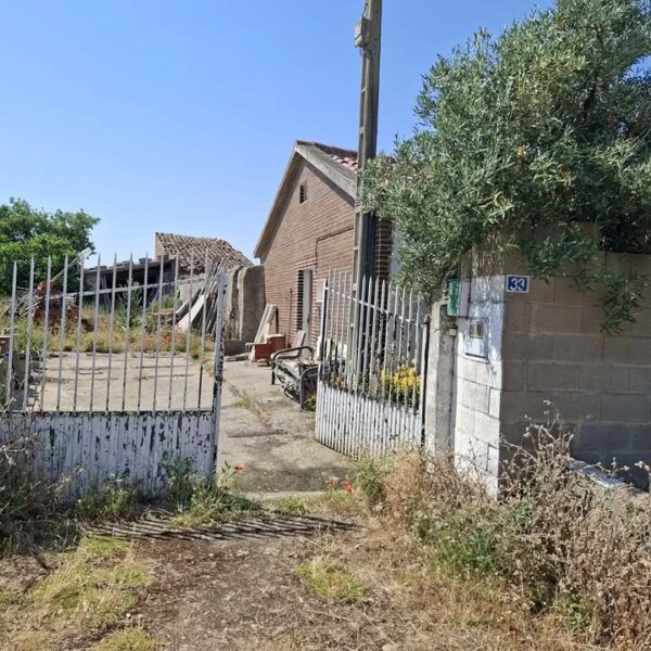 Entrada a una vivienda en Pobladura de Valderaduey con vegetación y cercas
