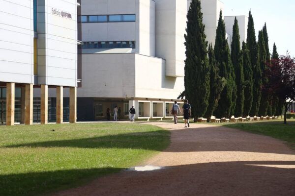 Edificio de la Universidad con estudiantes caminando por el campus