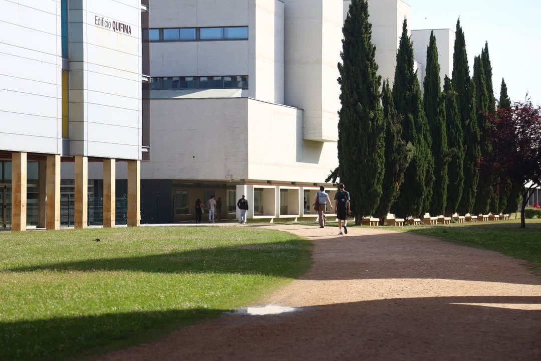 Edificio de la Universidad con estudiantes caminando por el campus