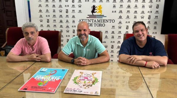 Tres hombres sentados en una mesa con carteles de conciertos