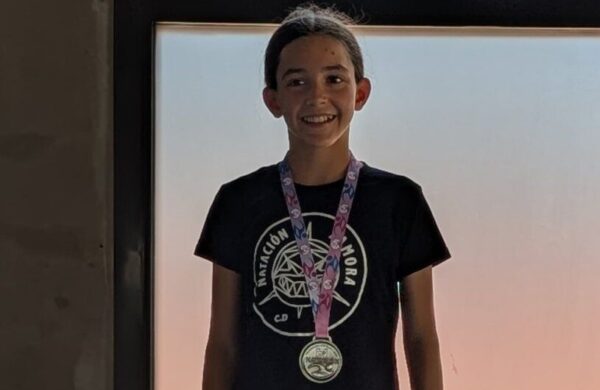 Mía Refoyo sonriente con medalla en el podio de natación