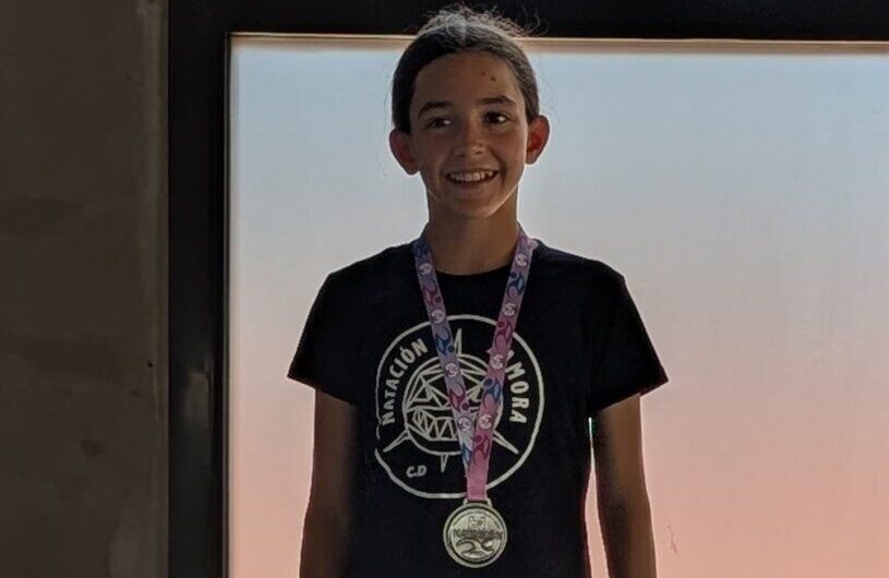 Mía Refoyo sonriente con medalla en el podio de natación