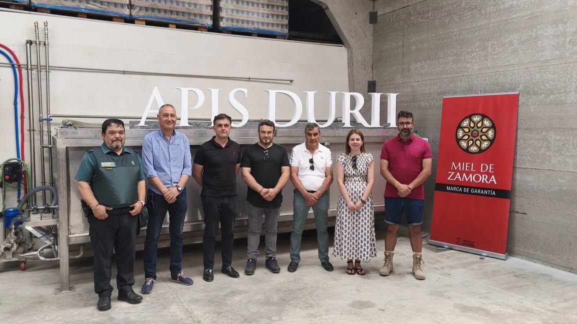 Grupo de personas en la inauguración de una línea de envasado de miel en Mombuey
