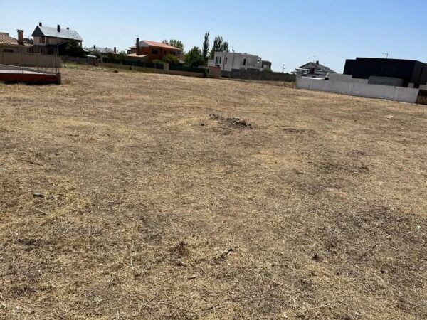 Terreno vacío y seco en Zamora, con casas alrededor.