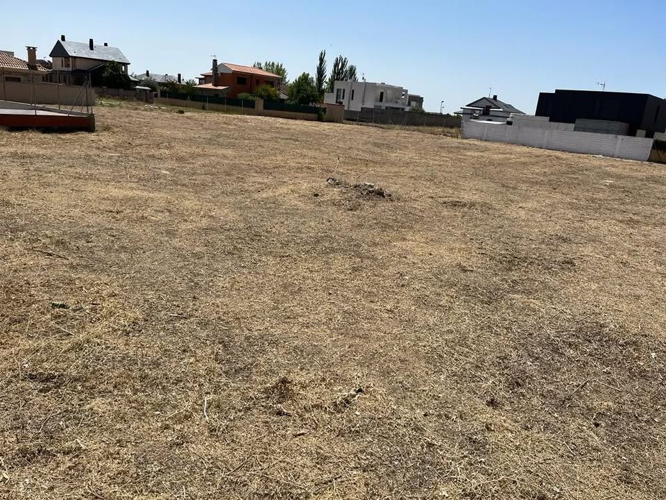 Terreno vacío y seco en Zamora, con casas alrededor.