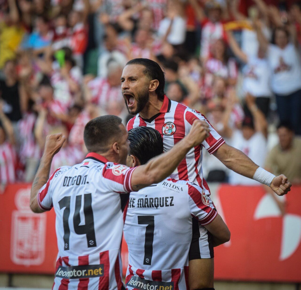 Jugadores del Zamora CF celebrando un gol en el estadio lleno de aficionados.