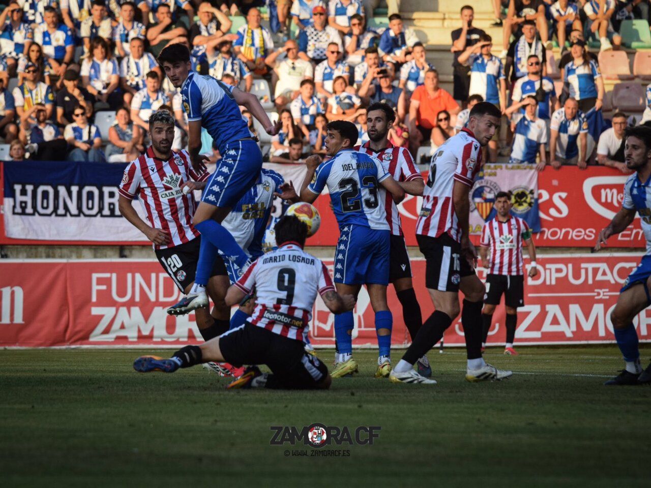 Jugadores del Zamora CF en un partido con afición en el fondo
