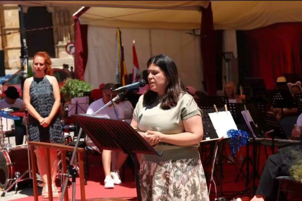 Mujer cantando en un evento musical al aire libre en Benavente