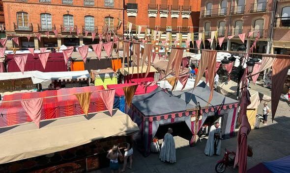 Vista del Mercado Medieval en Benavente con coloridos puestos y banderines