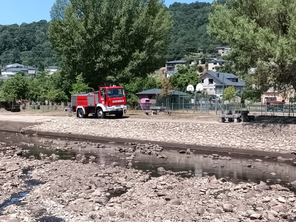 Bomberos limpiando la playa fluvial de Porto tras incendios