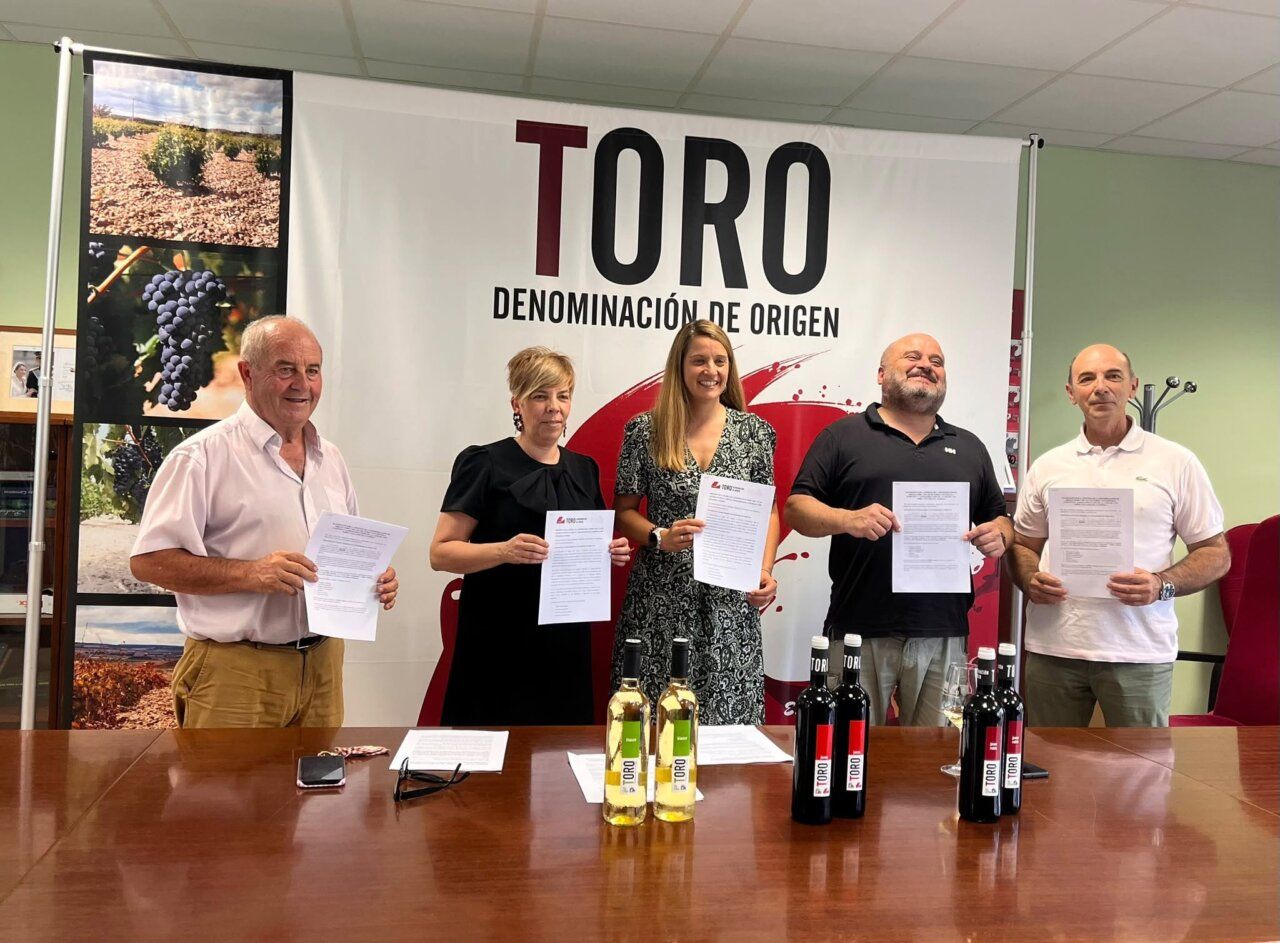 Representantes del Consejo Regulador de la D.O. Toro sosteniendo documentos en una mesa