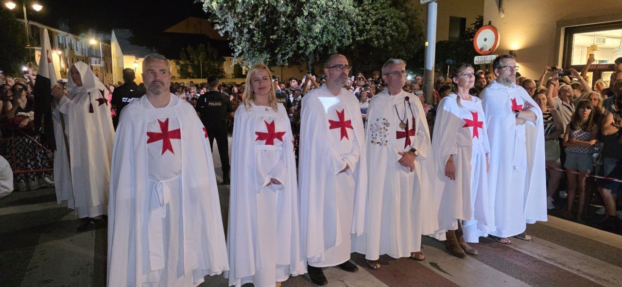Participantes en el desfile templario de Ponferrada con capas blancas y cruces rojas