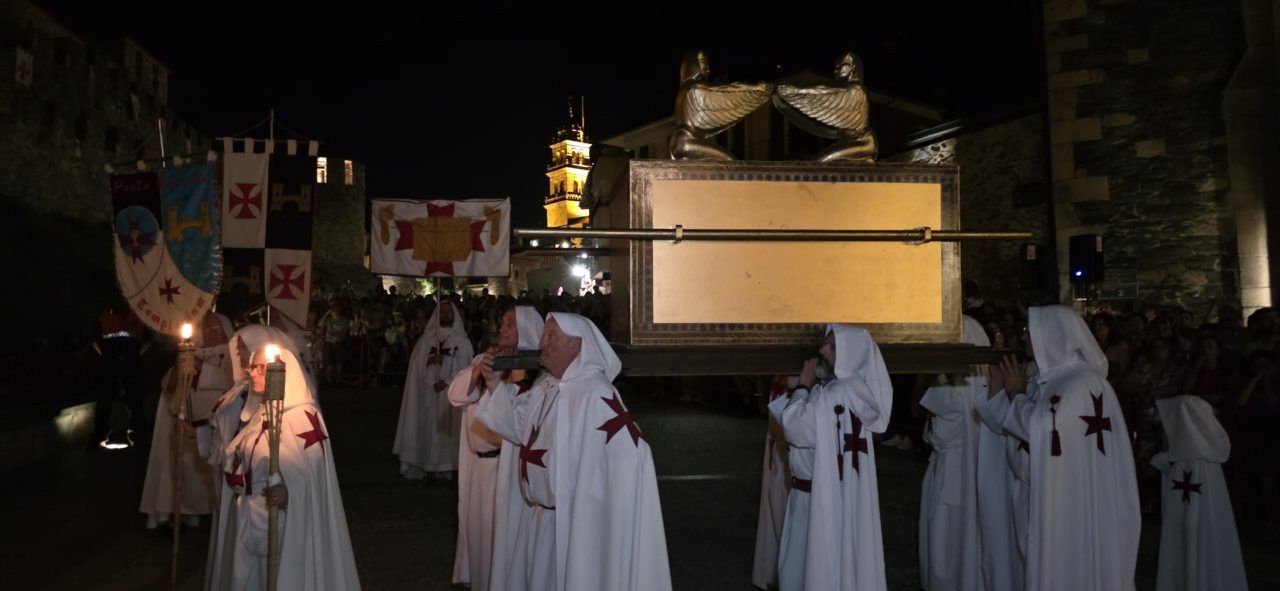 Participantes en el desfile templario de Ponferrada portando una estructura en la noche