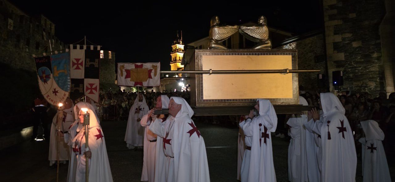 Participantes del desfile templario en Ponferrada con antorchas y estandartes.