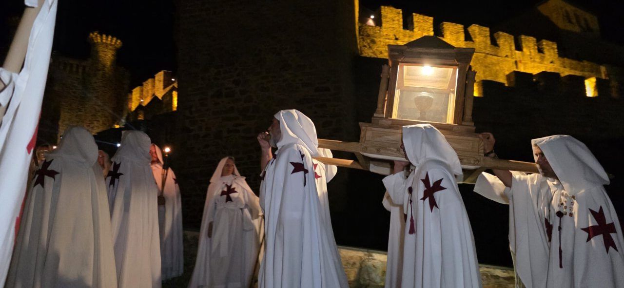 Participantes del desfile templario en Ponferrada con túnicas blancas y cruces rojas