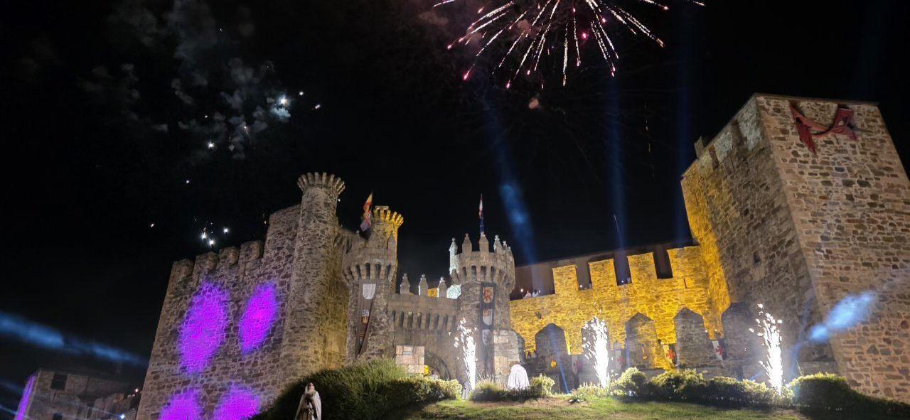 Castillo de Ponferrada iluminado con fuegos artificiales en la noche