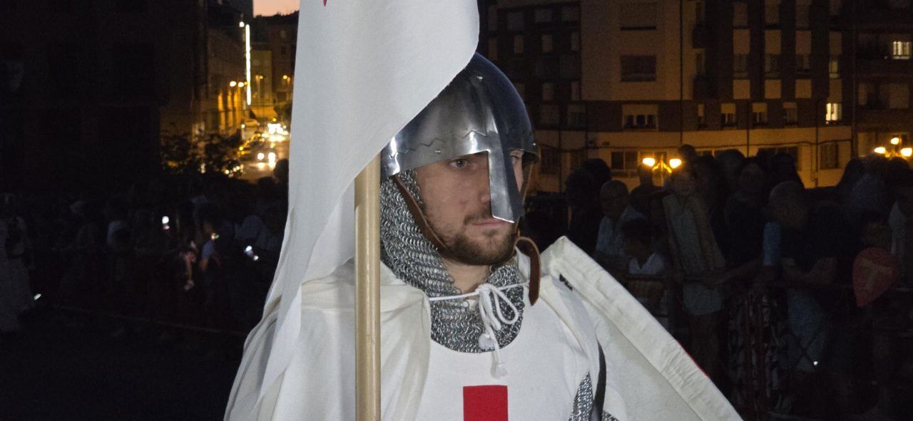 Caballero templario en desfile con bandera en Ponferrada
