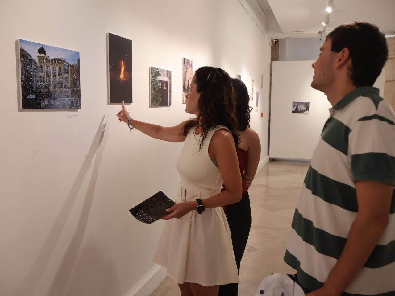 Jóvenes observando fotografías en la exposición Fauna Urbana en La Alhóndiga.