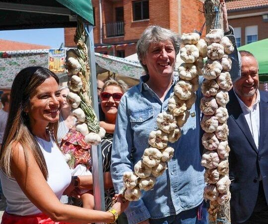 Personas en la Feria del Ajo sosteniendo ajos en Santa Marina del Rey