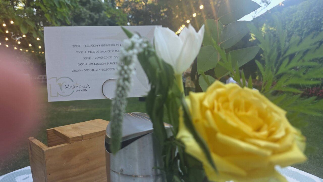 Mesa decorada con flores y menú del décimo aniversario del restaurante Maradela