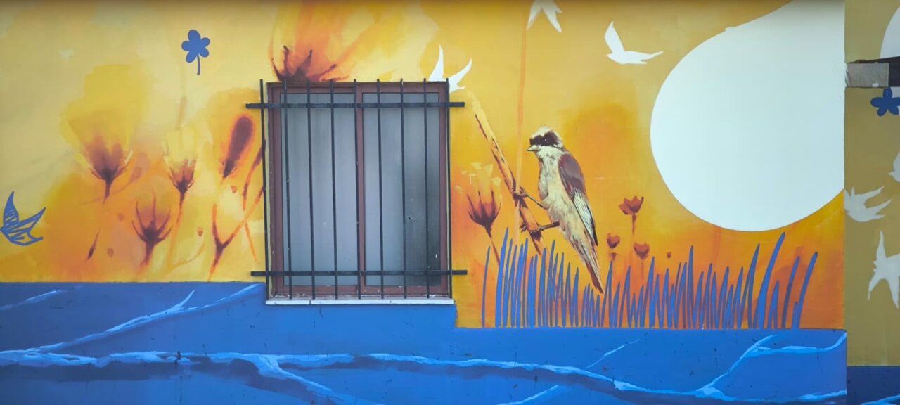 Mural colorido en los vestuarios de Los Pelambres con un ave y flores