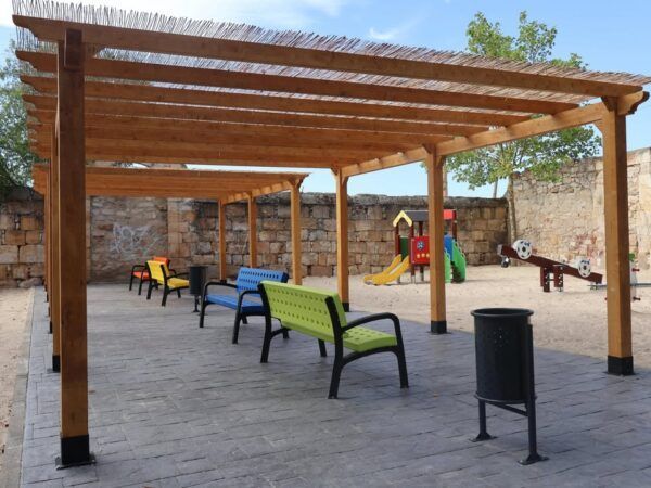 Parque infantil renovado con bancos de colores y juegos para niños