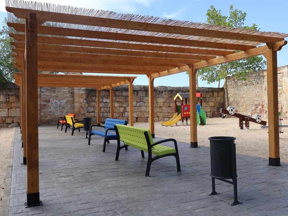 Parque infantil renovado con bancos de colores y juegos para niños