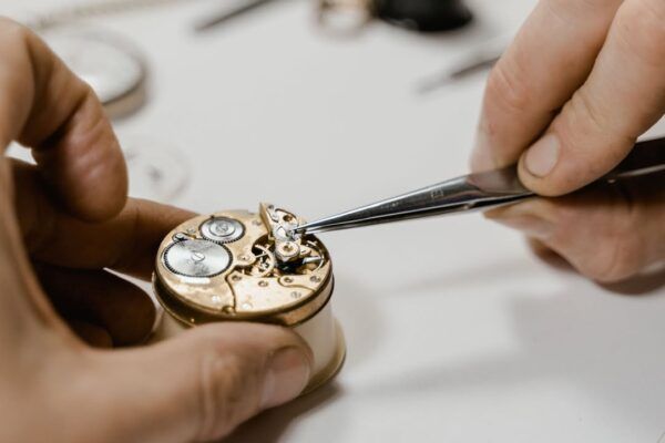 Persona trabajando en la reparación de un mecanismo de reloj