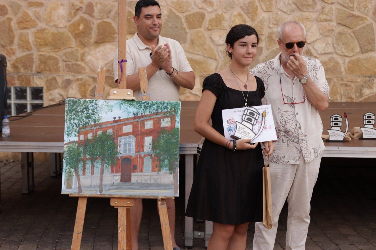 Ganadora del Certamen de Pintura Rápida sosteniendo su premio junto a otros participantes.