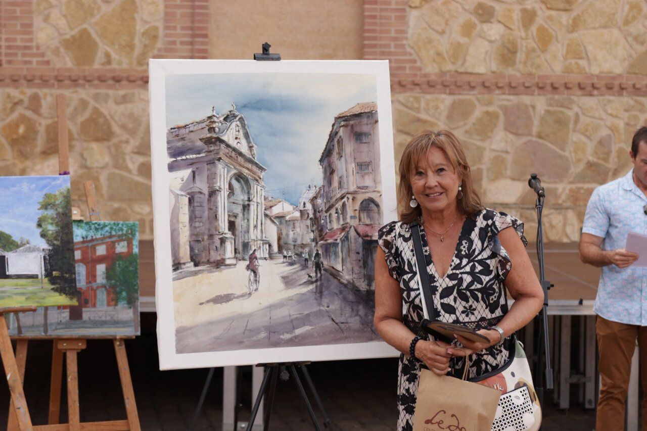 Participante sosteniendo una pintura en el Certamen de Pintura Rápida en Benavente.