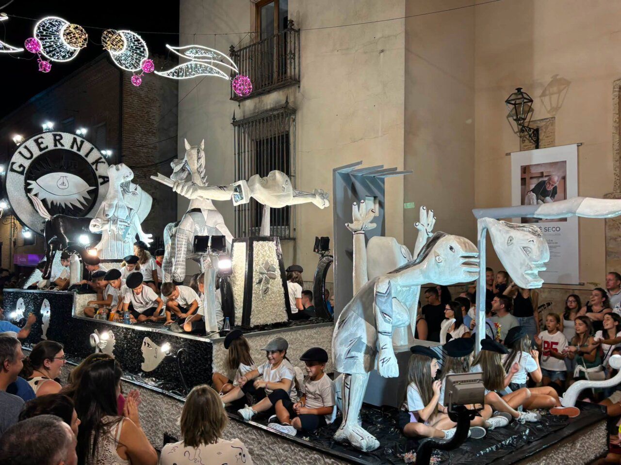 Carroza del desfile de San Agustín con figuras artísticas y niños
