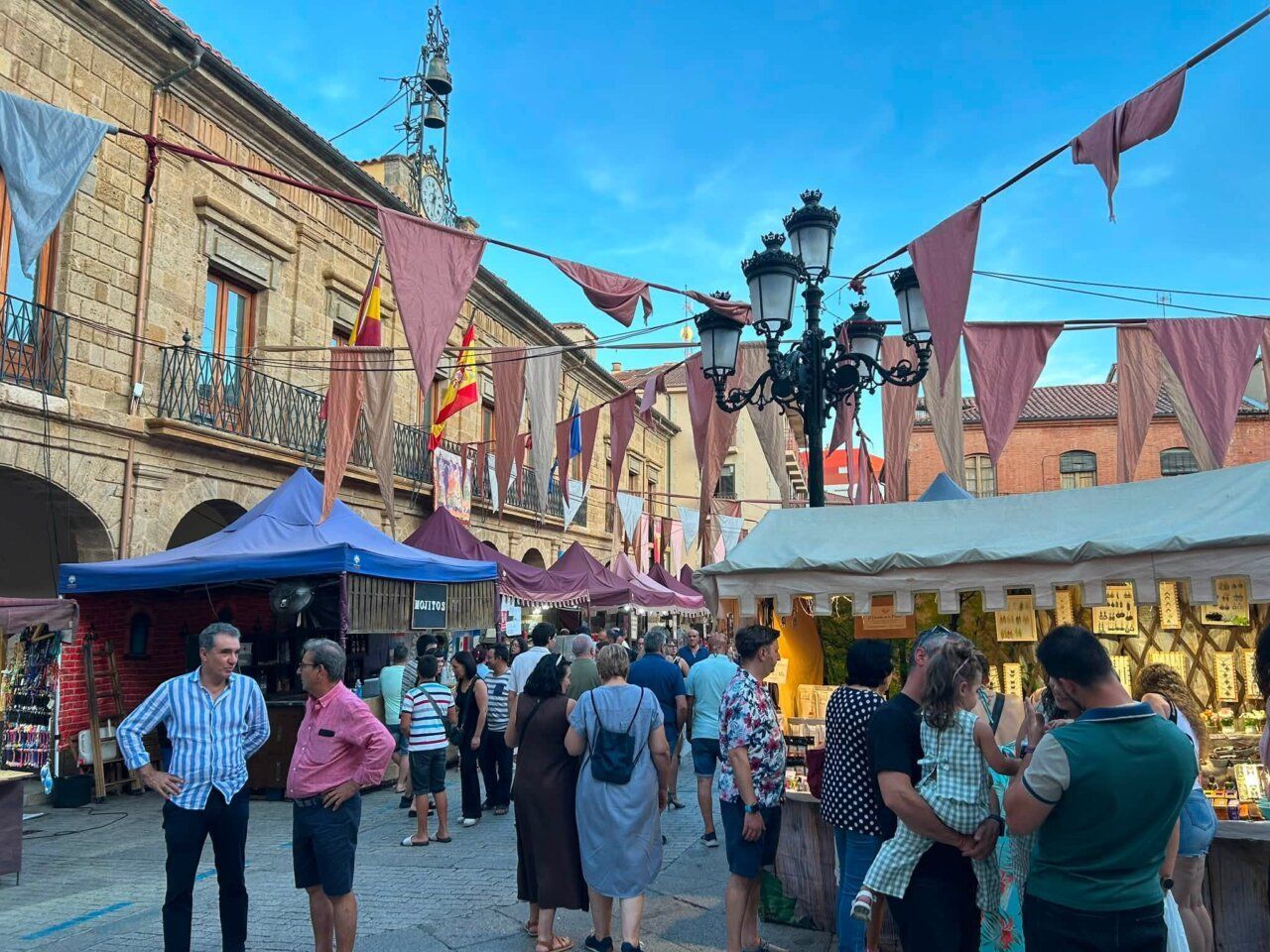 Gente disfrutando del Mercado Medieval en Benavente con decoraciones festivas
