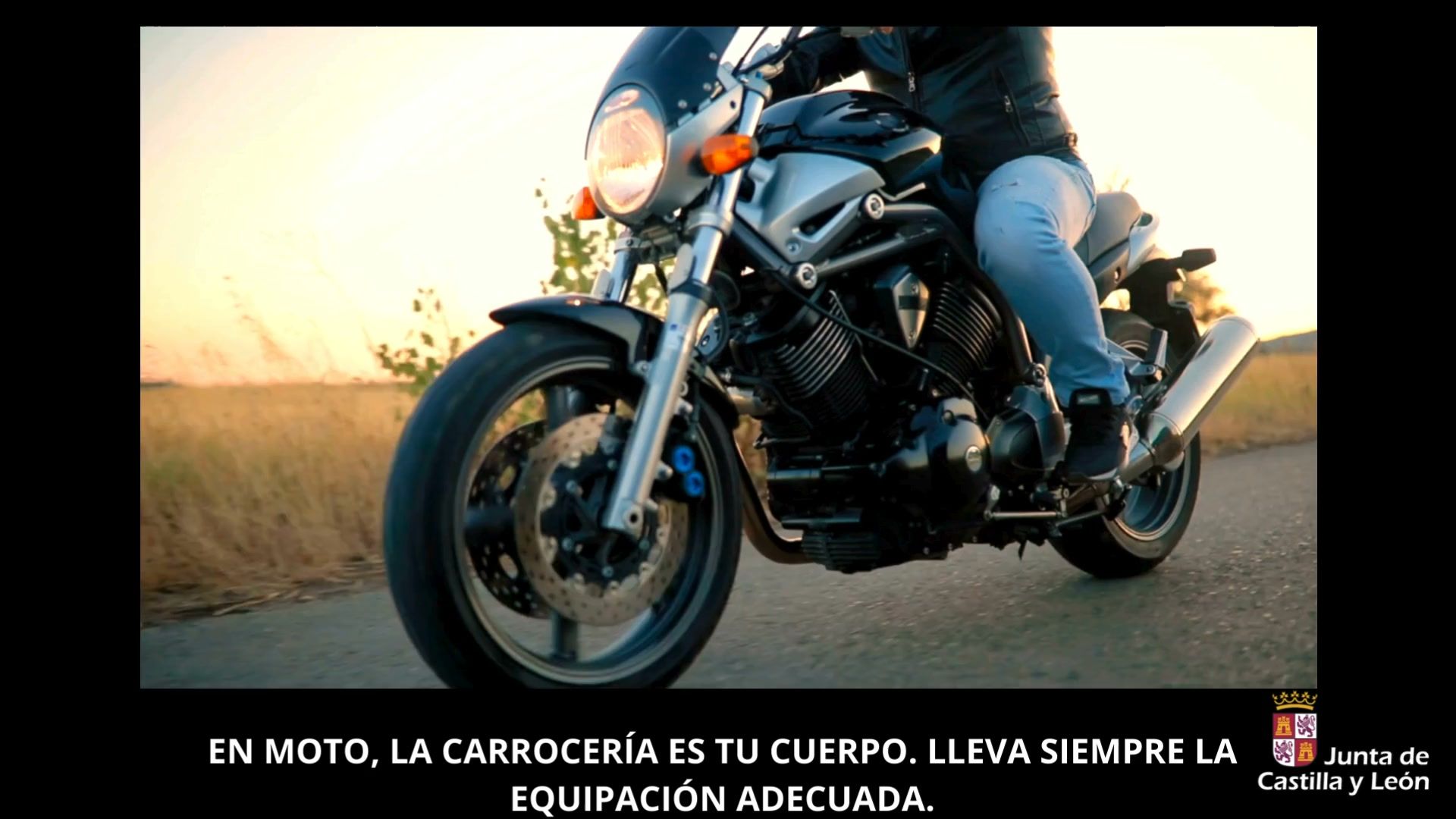 Motorista conduciendo una moto en carretera durante el atardecer