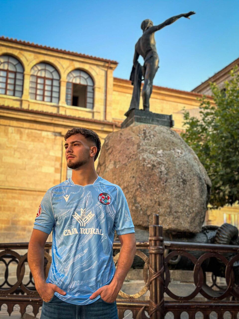 Jugador del Zamora CF con camiseta nueva frente a una escultura