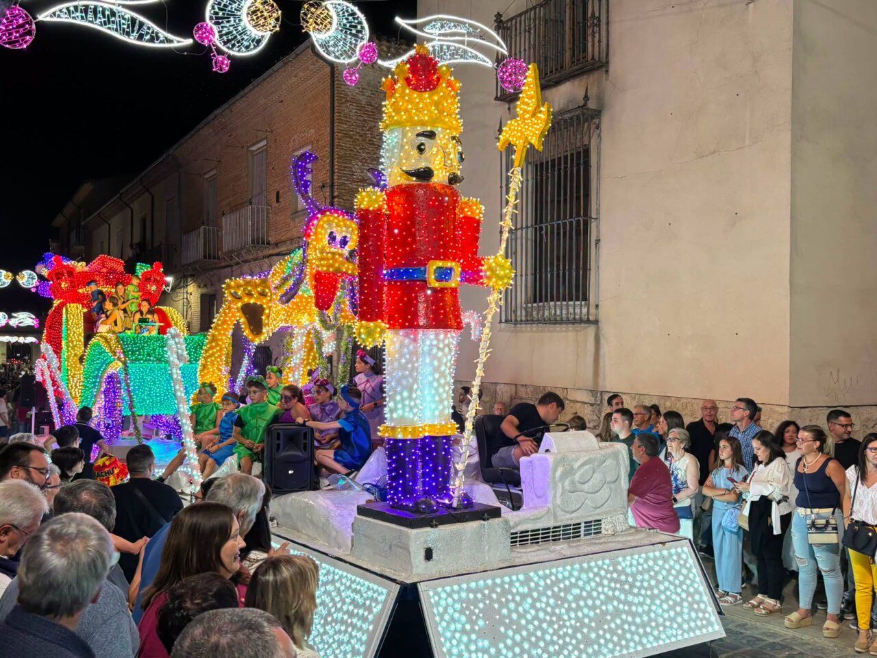 Carrozas iluminadas en el desfile de San Agustín 2026 con público disfrutando.