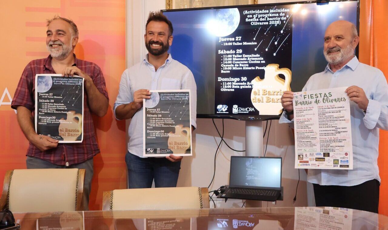 Tres hombres sosteniendo carteles de las fiestas del barrio de Olivares