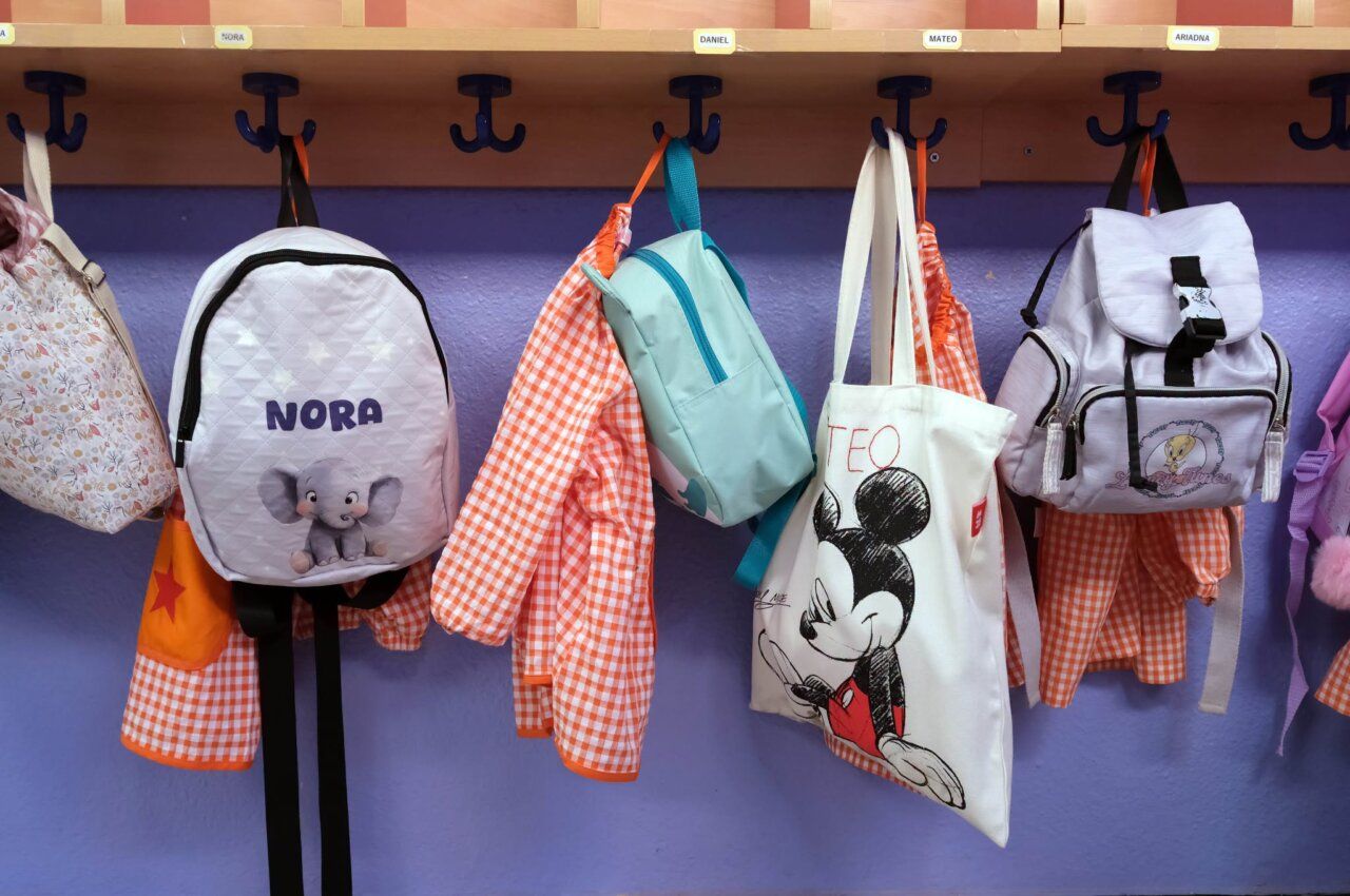 Mochilas y chaquetas en un aula de escuela infantil