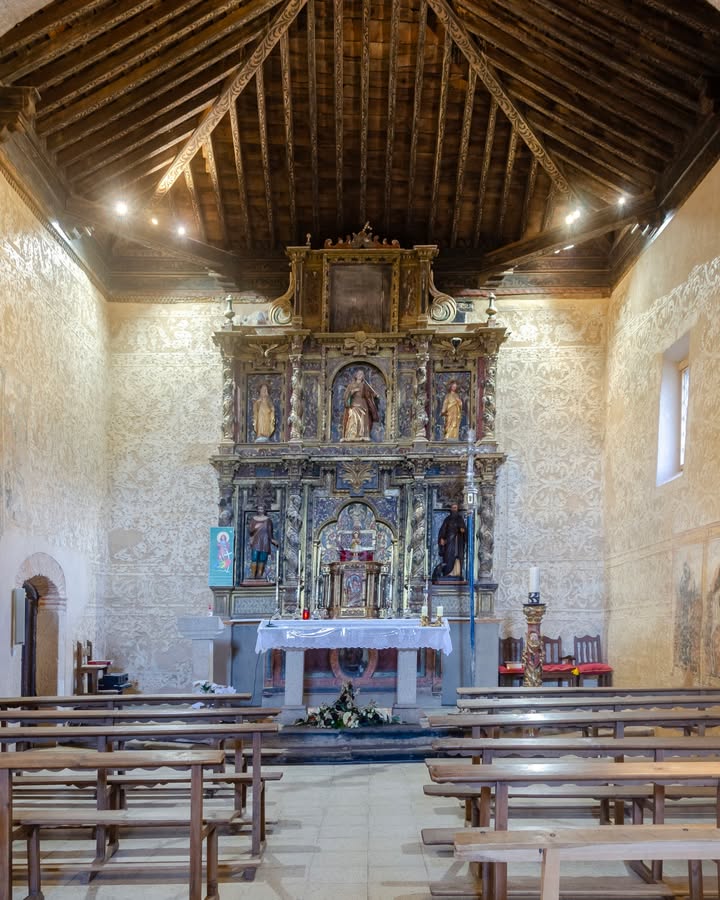 Interior de la Iglesia de Santa Eulalia con altar y bancos de madera