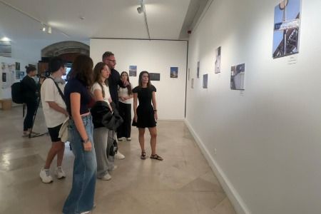 Grupo de personas observando una exposición fotográfica en una galería